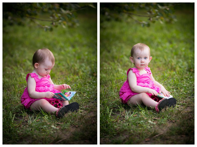 baby reading book in grass