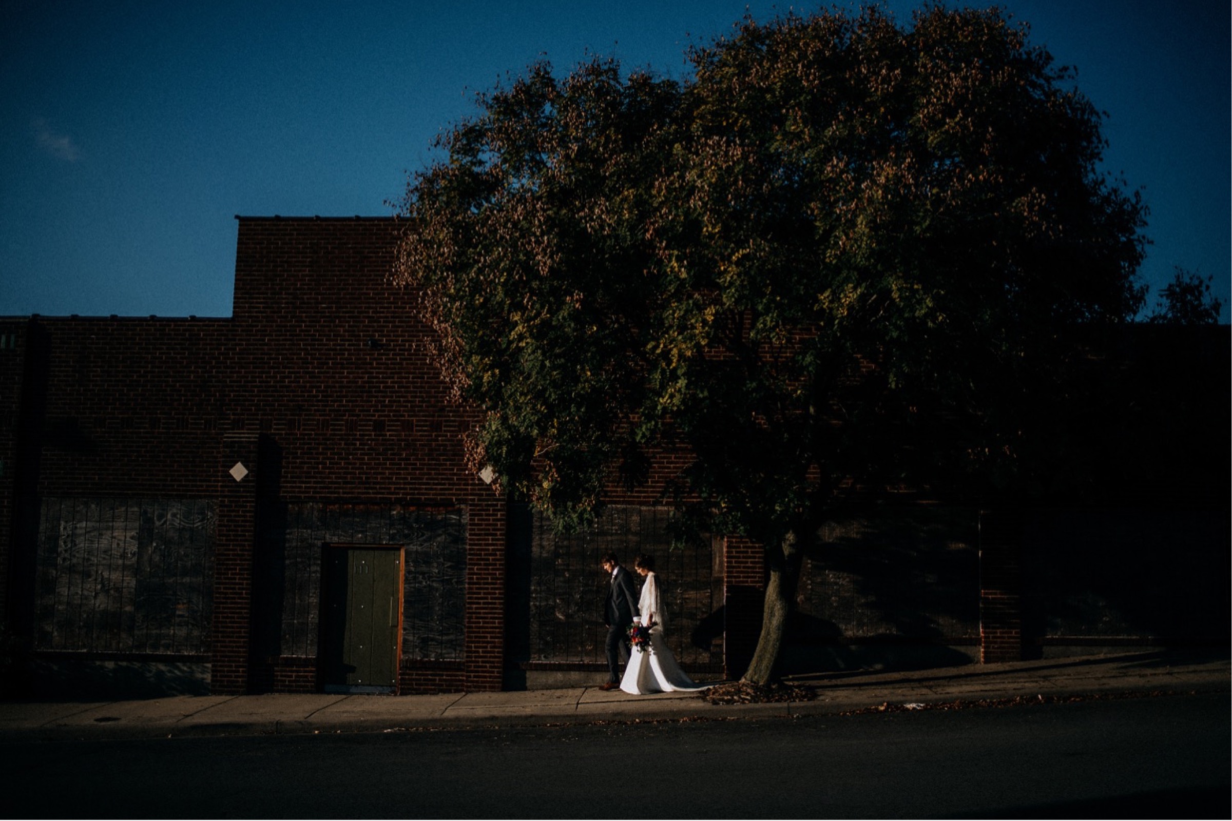 bride and groom walking down the street during the portrait time of their wedding day timeline
