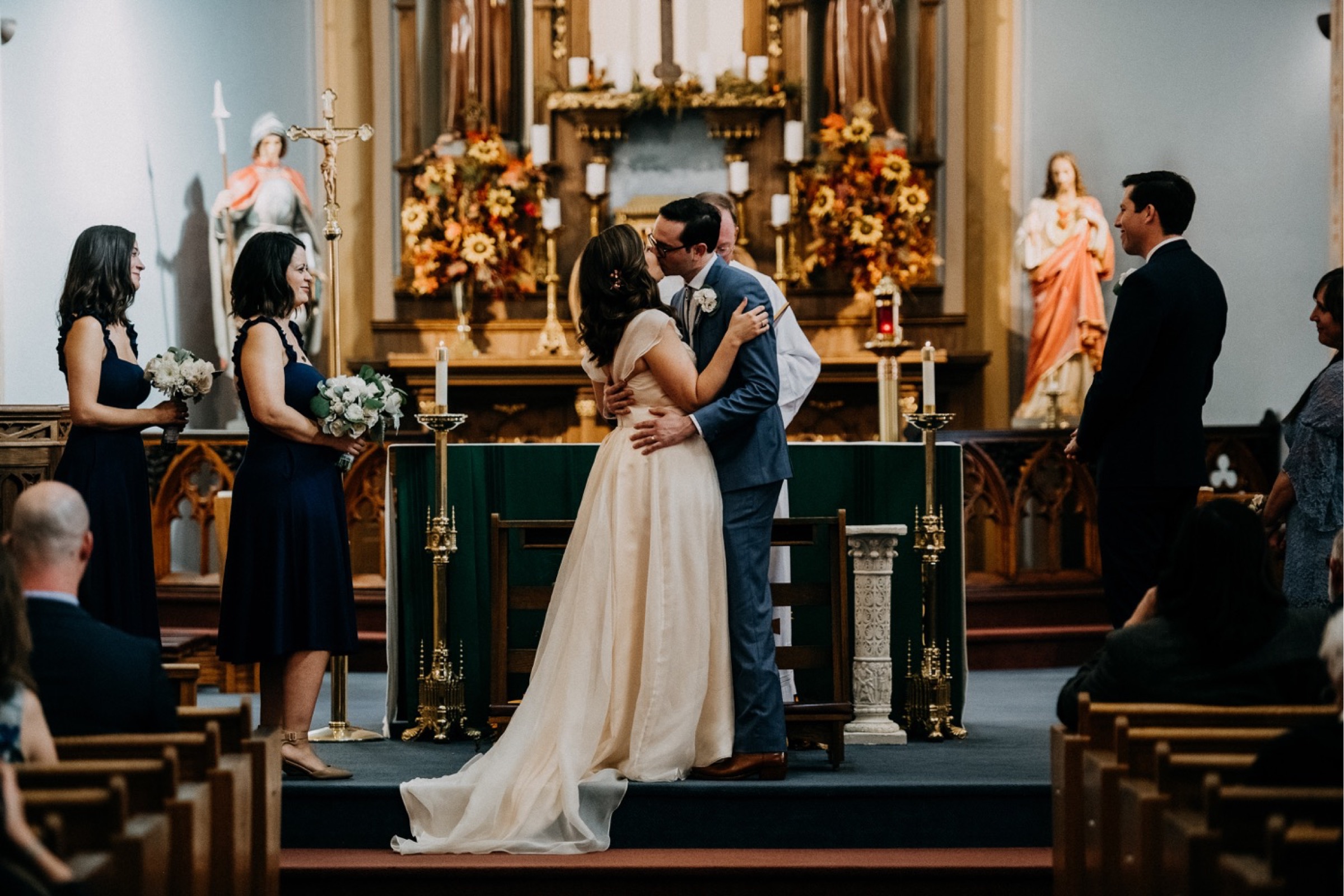 A couple have their first kiss in a historic old church in Hermann, MO during the ceremony portion of their wedding day timeline