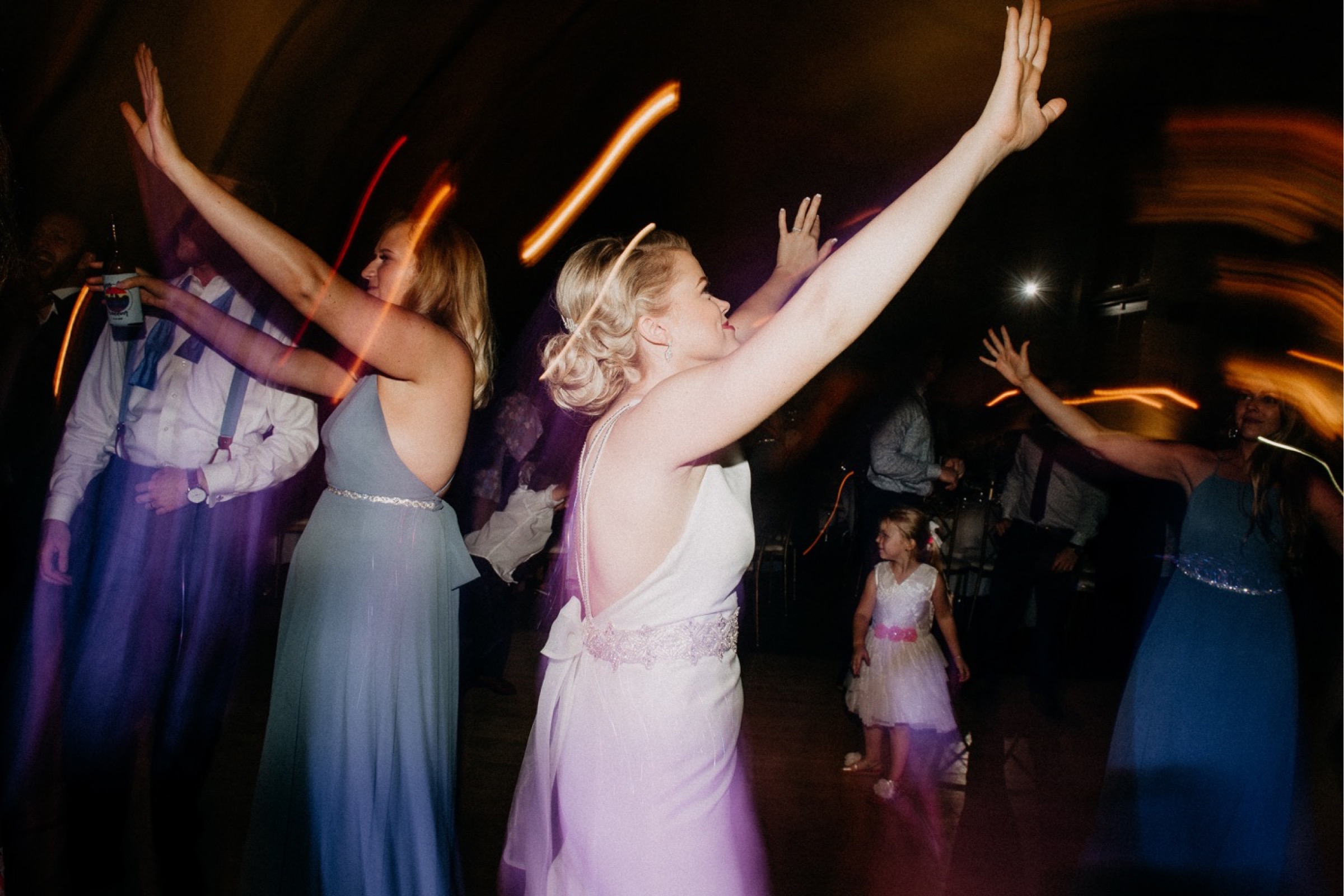 Guests and the bride dance and have fun during the reception portion of the wedding day timeline