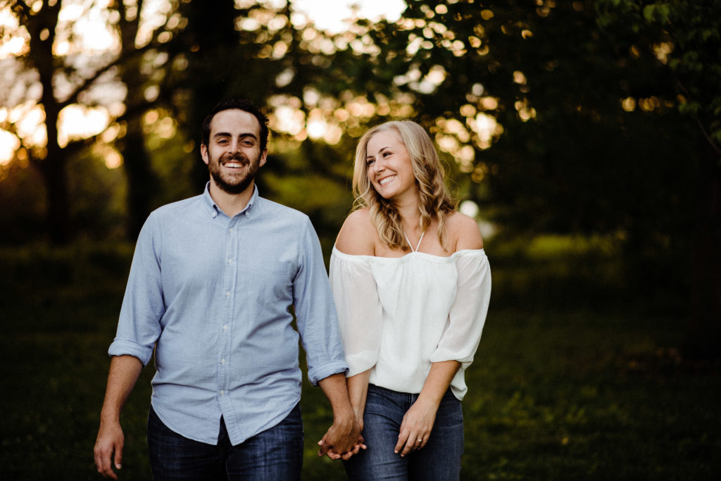a couple holds hands during their golden hour engagement session 